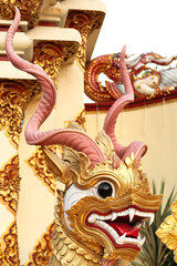 A golden statue of a horned dragon, dog, lion, guardian, deity, spirit, mythological creature next to the entrance to the Wat Muen Tum, Muentoom Temple, Chiang Mai, Thailand