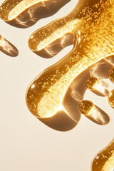 Fototapeta premium Golden cosmetic and skincare serum oil liquid product texture droplets close up detail, beauty and hygiene commercial background against light white background.