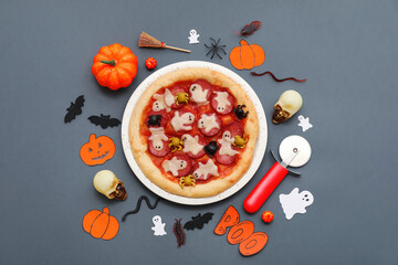 Composition with tasty Halloween pizza, cutter and different decorations on dark background