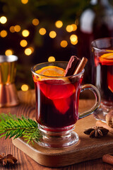 Mulled wine with orange and cinnamon in a glass glass. Hot wine with cinnamon. Warming winter drink with orange and cinnamon. Hot tea with orange and cinnamon.