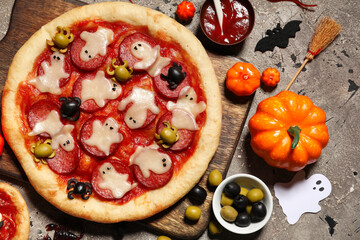 Composition with tasty Halloween pizza, ingredients and decorations for Halloween on grunge background