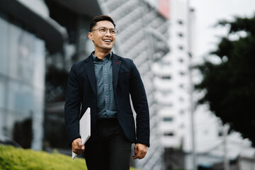 Confidently Striding Towards Success: A young, successful Asian businessman walks confidently...