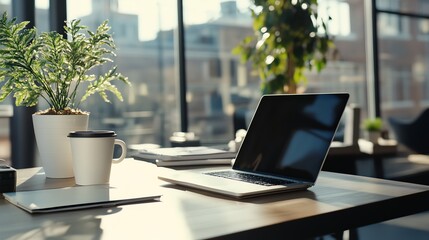 A laptop computer and a cup of coffee on a desk next to a window.