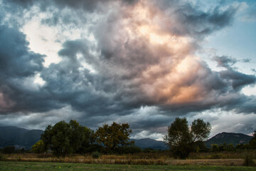 A sky full of beautiful clouds, lit by the sun that has set behind the mountain. Before that it was raining.
