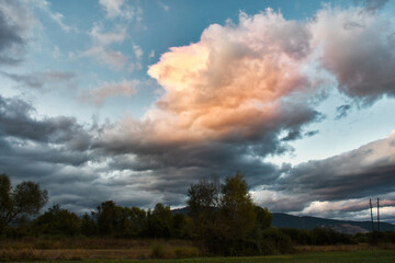 A sky full of beautiful clouds, lit by the sun that has set behind the mountain. Before that it was raining.