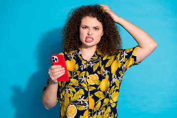 Photo of angry puzzled lady dressed print shirt chatting modern device empty space isolated blue...