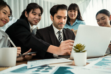 Diverse group of business analyst team analyzing financial data report paper on office table. Chart and graph dashboard by business intelligence analysis for strategic marketing planning Habiliment