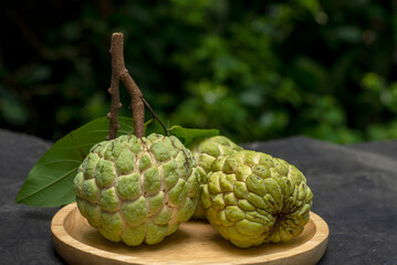 Fototapeta premium Light green custard apples are placed on a wooden plate