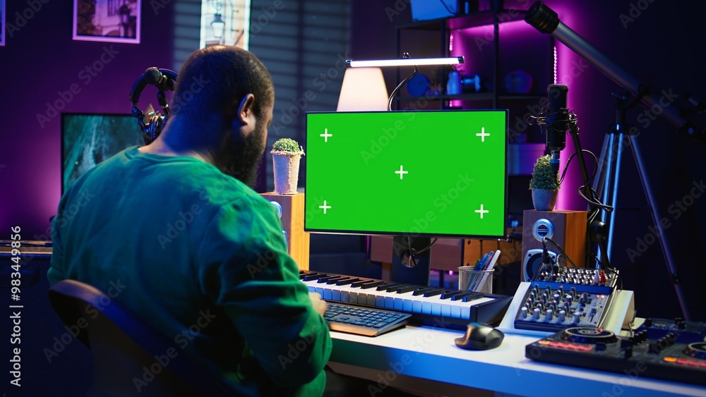 Poster producer composing music with electronic keyboard notes and green screen display on pc, post product