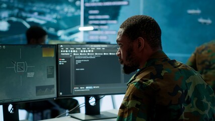 Soldier working with AI intelligence on pc in control room, processing live data on cctv systems. Surveillance efforts to support field missions and defense operations, national security. Camera A.