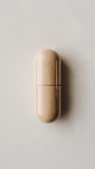 A solitary beige capsule standing upright on a white surface
