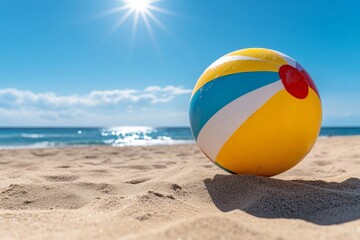 Obraz premium A beach ball bouncing on the sand, with the sun shining and the sea in the background