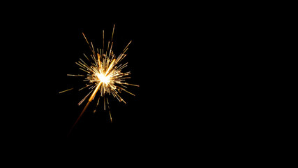 Fototapeta premium white sparkler on a black background, large space for copy