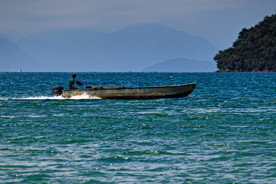 motor boat crossing the calm sea in front of Paraty Mirim beach.