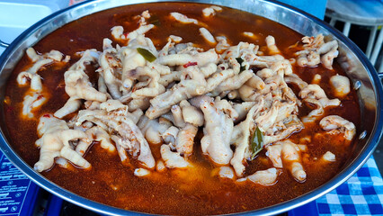 Chicken feet with spicy chili sauce or ceker mercon on a serving clay plate