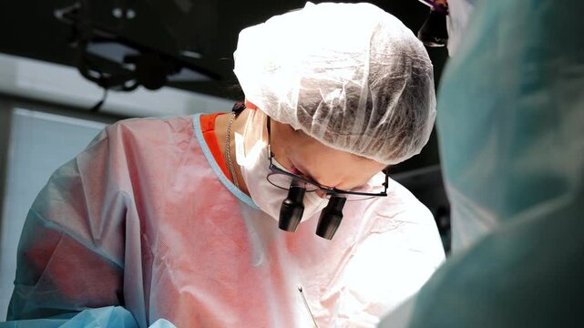 Skilled team doctors and assistants performs life-saving surgery modern microsurgery modern hospital. Doctors and medical team execute critical operation contemporary microsurgery modern hospital.