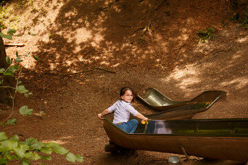 Little girl with glasses slides down metal slide in park. Children's fun concept