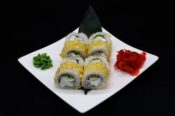 Prepared sushi rolls on a white plate on a black background