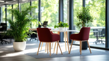 A bright office area featuring two elegant red chairs around a white table, surrounded by lush green plants, creating a vibrant yet serene workspace.