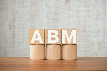 There is wood cube with the word ABM. It is an abbreviation for Account Based Marketing as...