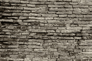 Surface of the red brick wall is very old, damaged, dirty and covered with black mold.
