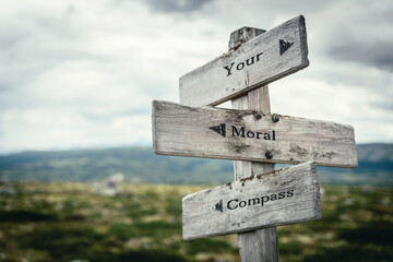 your moral compass text quote on wooden directional signpost outdoors in nature