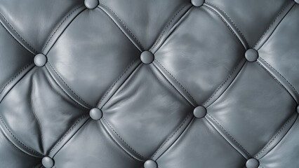 Naklejka premium Close-up of black leather tufted upholstery with buttons, showing a soft and luxurious texture.