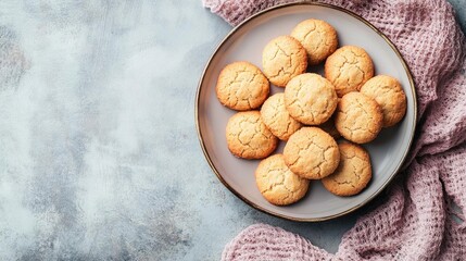 Delicious homemade cookies arranged on a gray plate, accompanied by a cozy pink blanket, perfect for a sweet treat.
