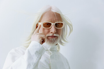 Portrait of a stylish older man with white hair and glasses, exuding confidence and creativity...