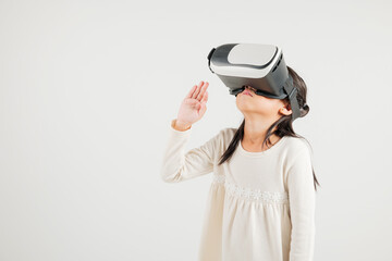 Portrait Asian smiling kid girl touching at something in a virtual reality glasses headset studio shot isolated white background, Excited happy kindergarten child using VR play simulation game