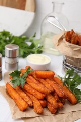 Sweet potato fries, parsley and sauce on table, closeup
