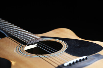 Fototapeta premium Acoustic guitar close-up on black background