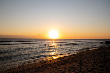 people playing and watching the sunset on the beach