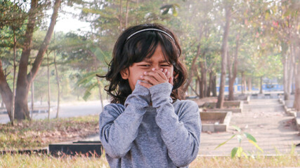A little girl is covering her nose because of air pollution