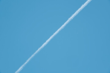 青空に走る長い飛行機雲　旅行・航空機・アウトドアの背景