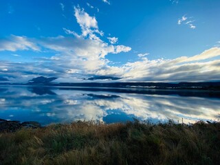 Beautiful views of mountains and blue sky with clouds reflect in the Lake water 