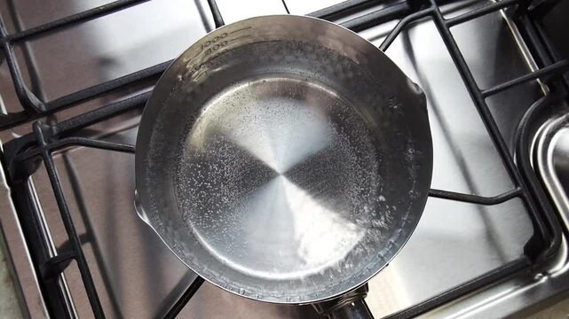 鍋の沸騰したお湯に出汁パックを入れるシーン