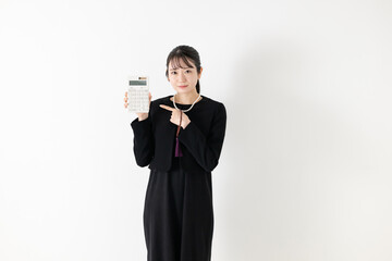 電卓を持つ喪服の女性