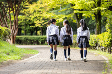 制服を着て歩く学生の後ろ姿