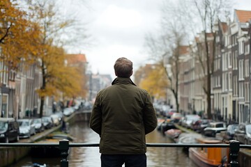 Fototapeta premium Man Standing on a Bridge in Amsterdam