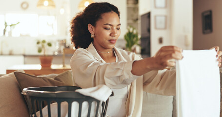 Woman, laundry and fold clothes in basket with fresh linen, spring cleaning and household chores on...