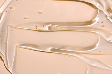Close up gel texture of cosmetic products. transparent cream on a beige background with bubbles. macro photo. blur and selective focus.