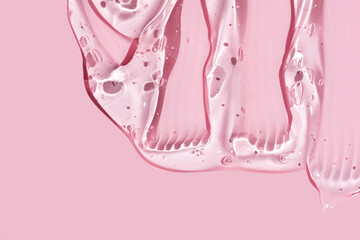 Sample of cosmetic gel on light pink surface. Abstract gel texture on pink background