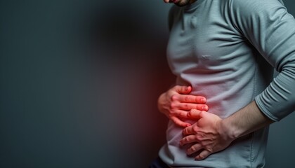 A man with a stomach ache is holding his stomach