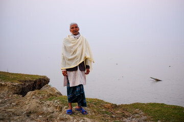 South asian elderly person enjoying calmness of river in his retired leisure days