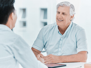 Doctor, consultation and happy senior patient in clinic office for healthcare, checkup or insurance. Medical worker, man and conversation for help, exam or geriatric treatment in hospital appointment