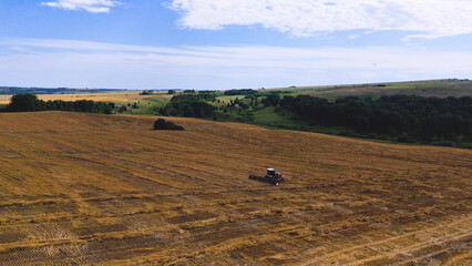 Obraz premium a combine harvester in a wheat field performs harvesting operations