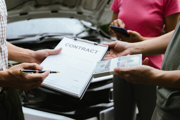 Car rental dealer is signing a rental contract with a professional salesperson. The agent will explain the details about car insurance and maintenance to ensure a smooth rental and service process.