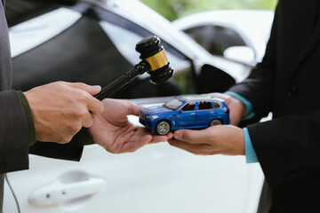 A judge in a courtroom presides over a legal case involving a car accident claim. The anxious driver awaits the verdict, while lawyers present evidence of vehicle damage for the insurance decision.