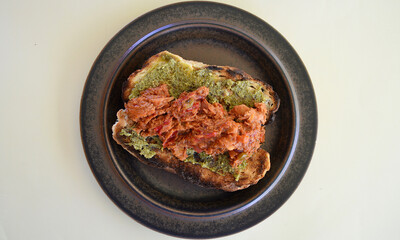 A tuna and bean mix with BBQ sauce on toasted cob bread with basil pesto.